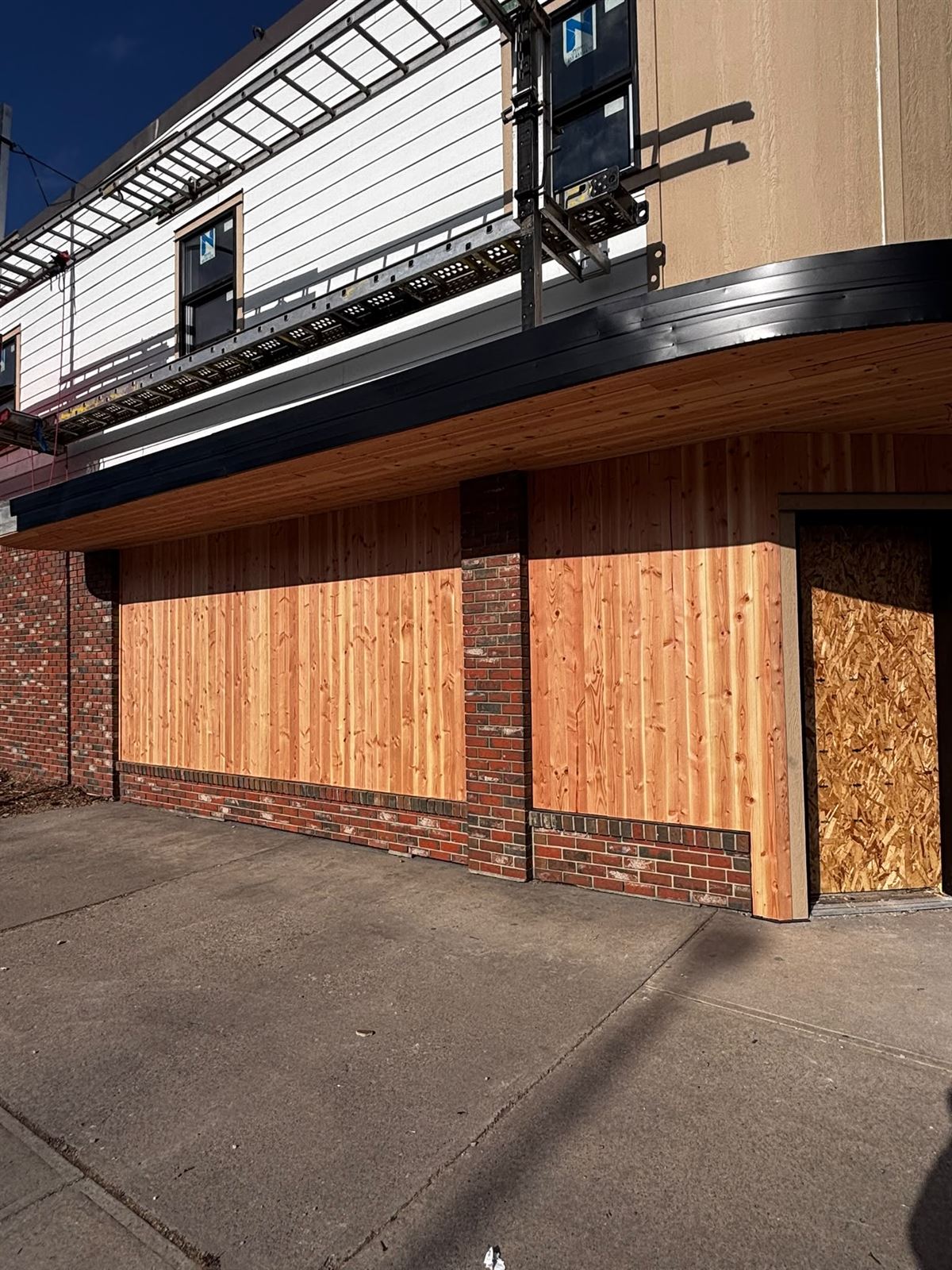 Storefront canopy with cedar soffit, new siding and brick below