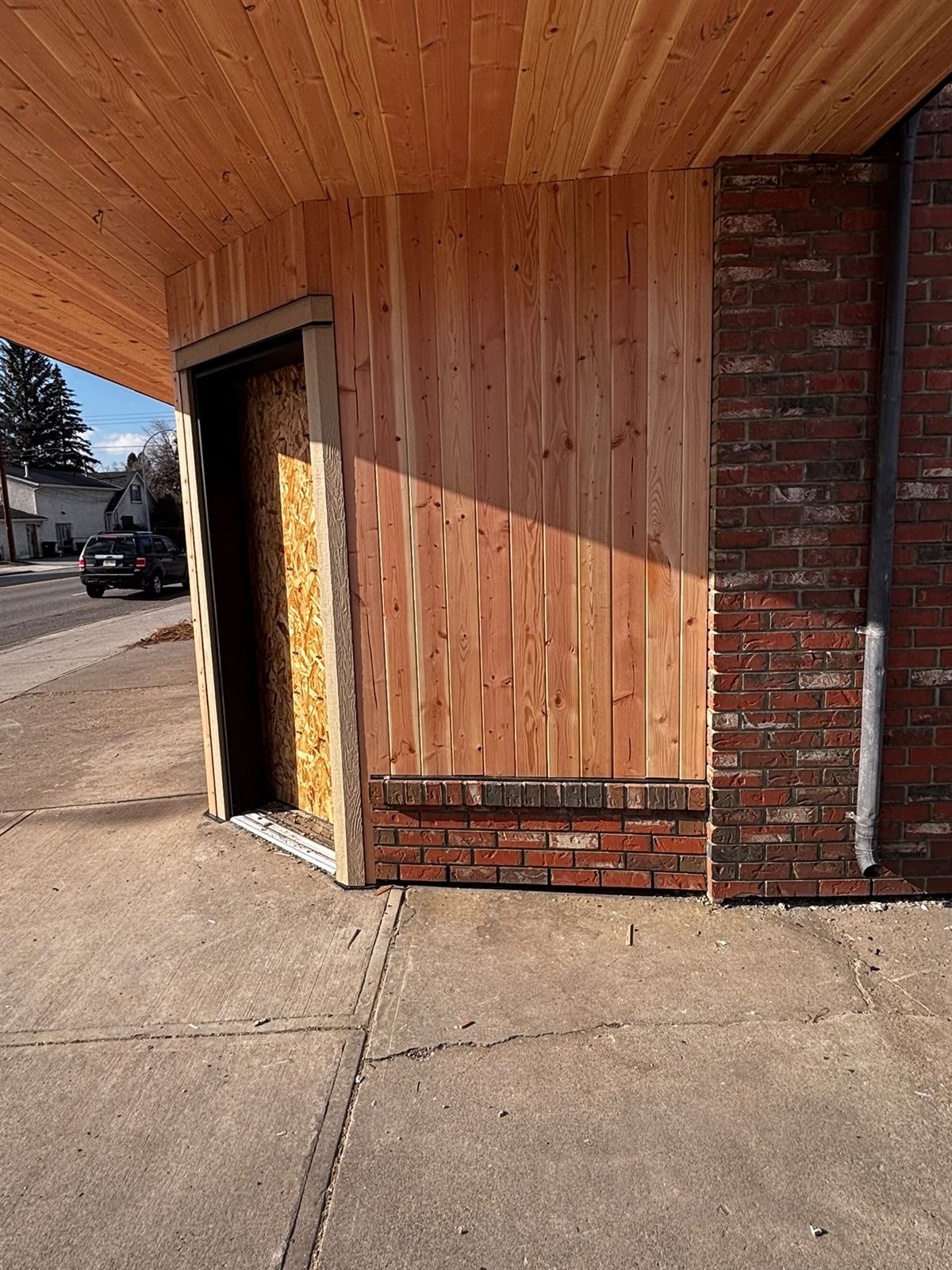 Commercial storefront renovation with cedar soffit and fir cladding over brick