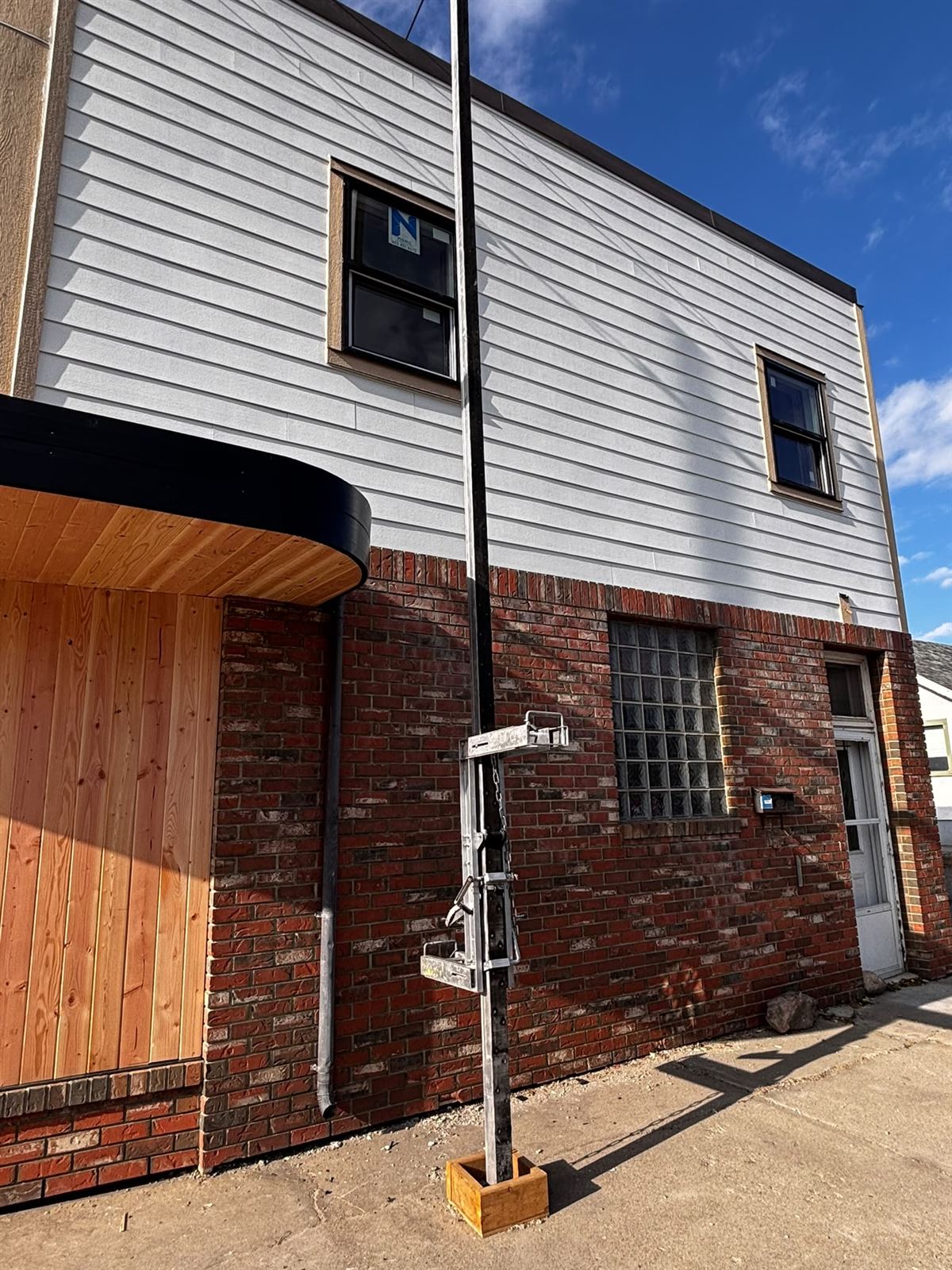 Siding installation on a commercial building using a ladder lift