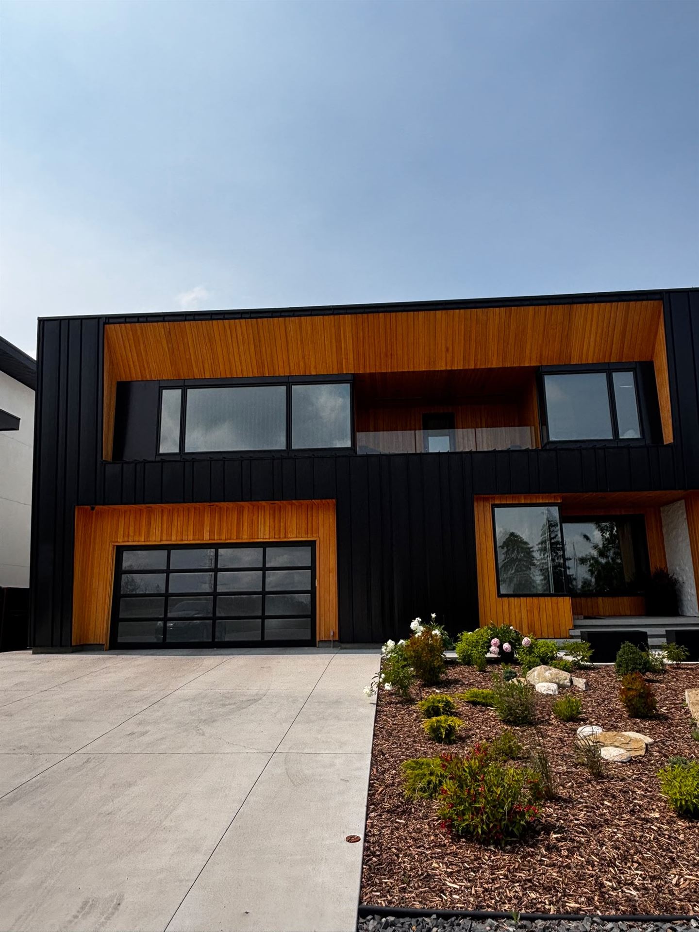 Finished modern exterior with black metal siding and cedar accents