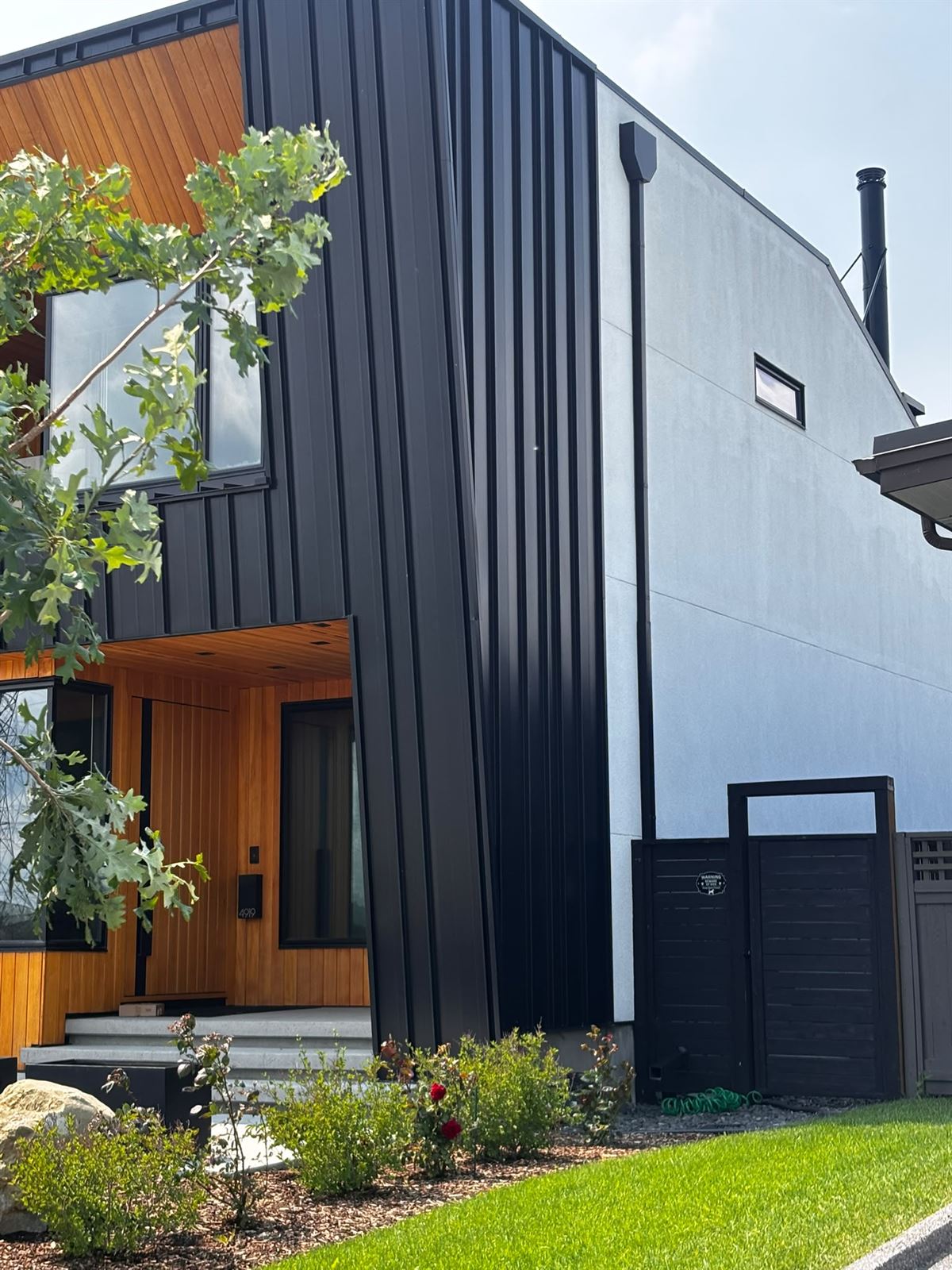 Black metal siding with cedar entry feature