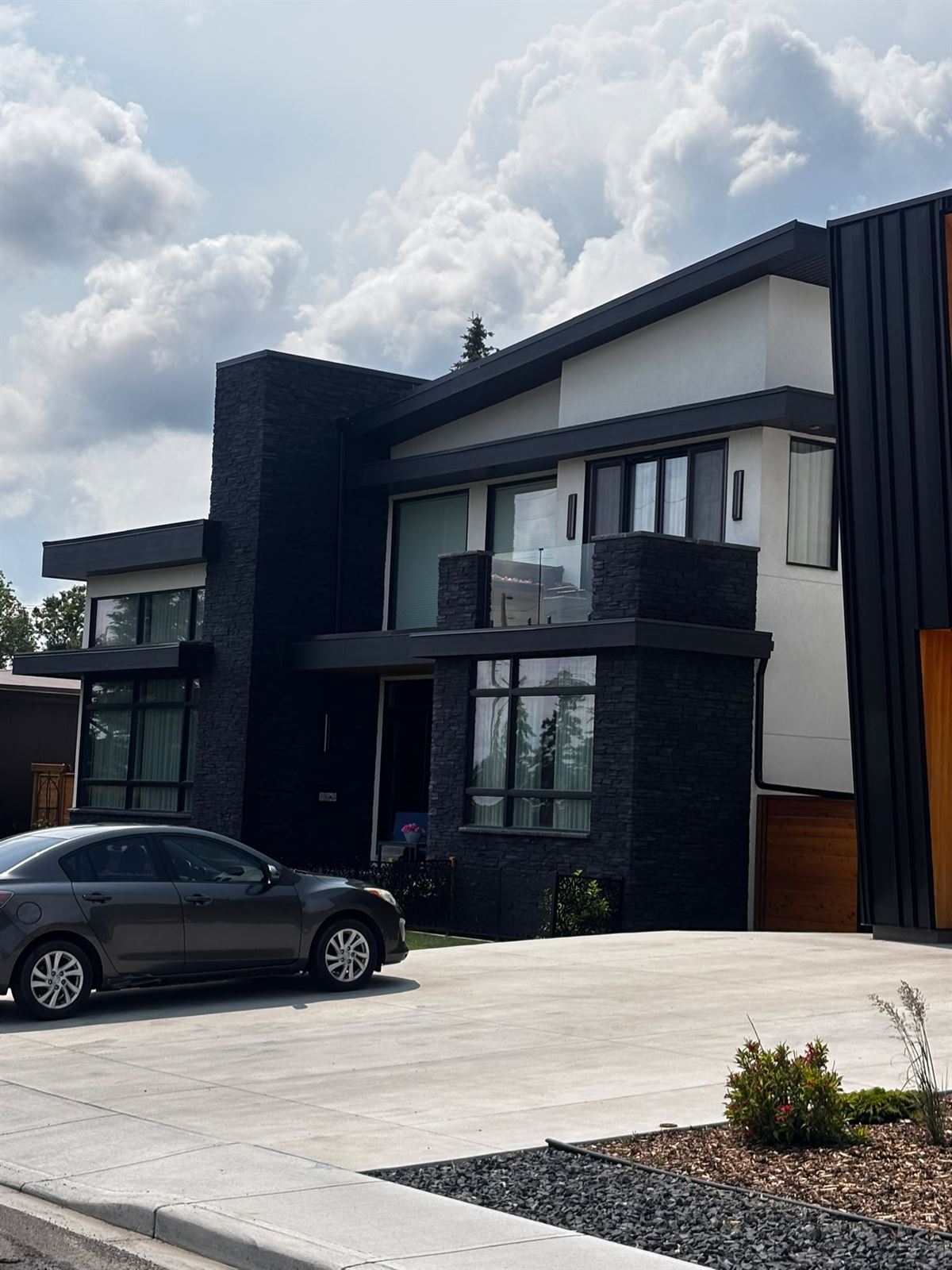 Finished modern exterior with stacked stone and stucco