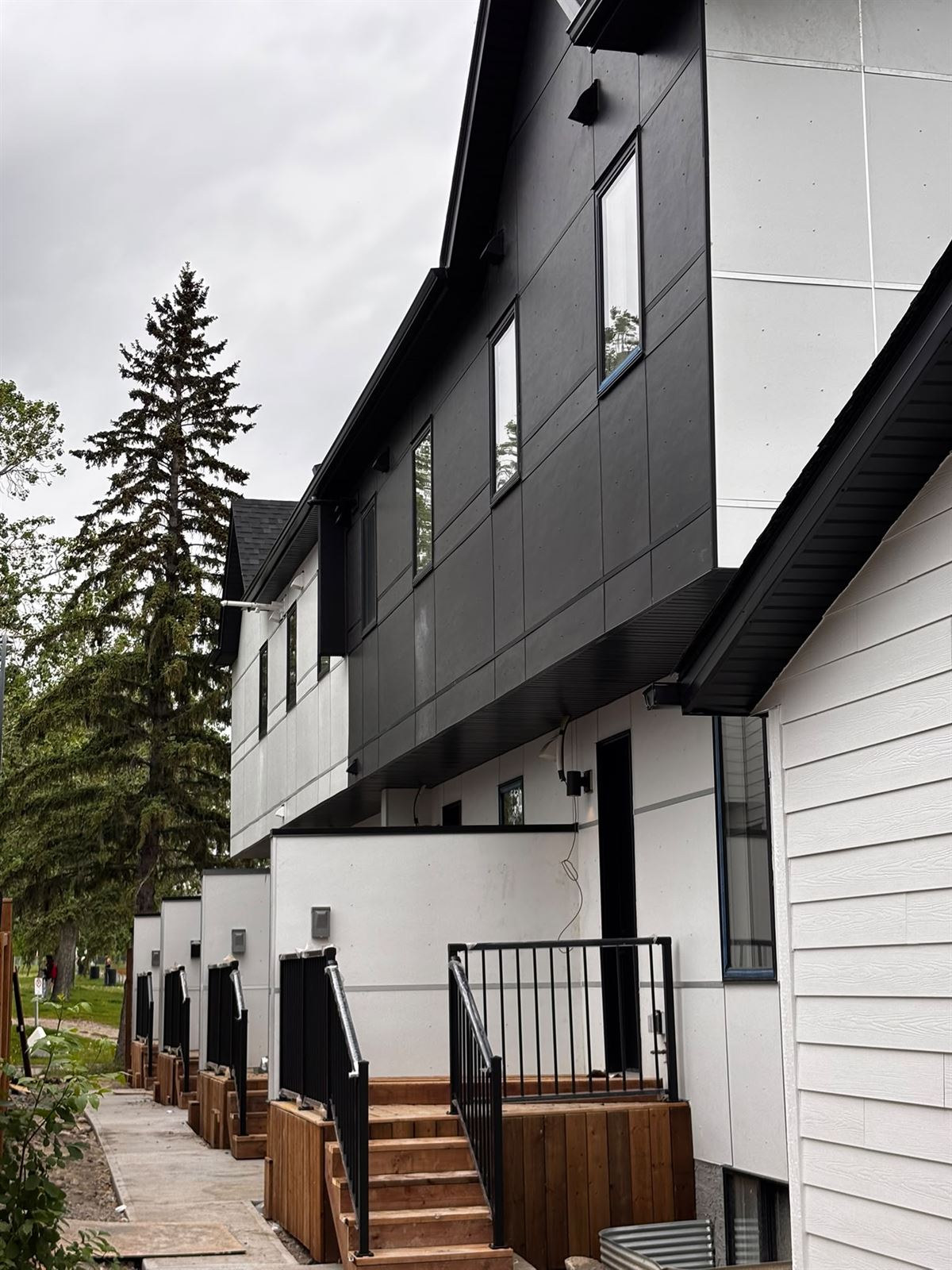 New townhome exteriors with hardie panel siding and cedar deck stairs