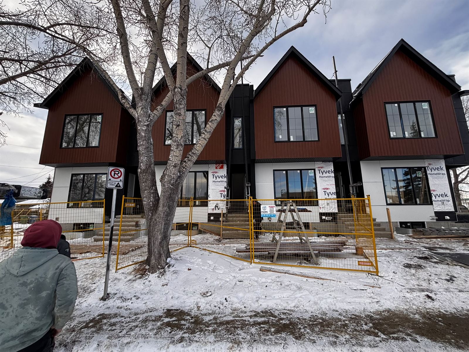 Board and batten and wood-look siding going onto a Calgary townhome row