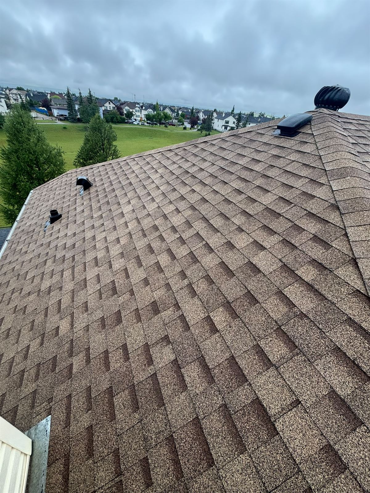 Turbine vent and brown shingles on a finished roof