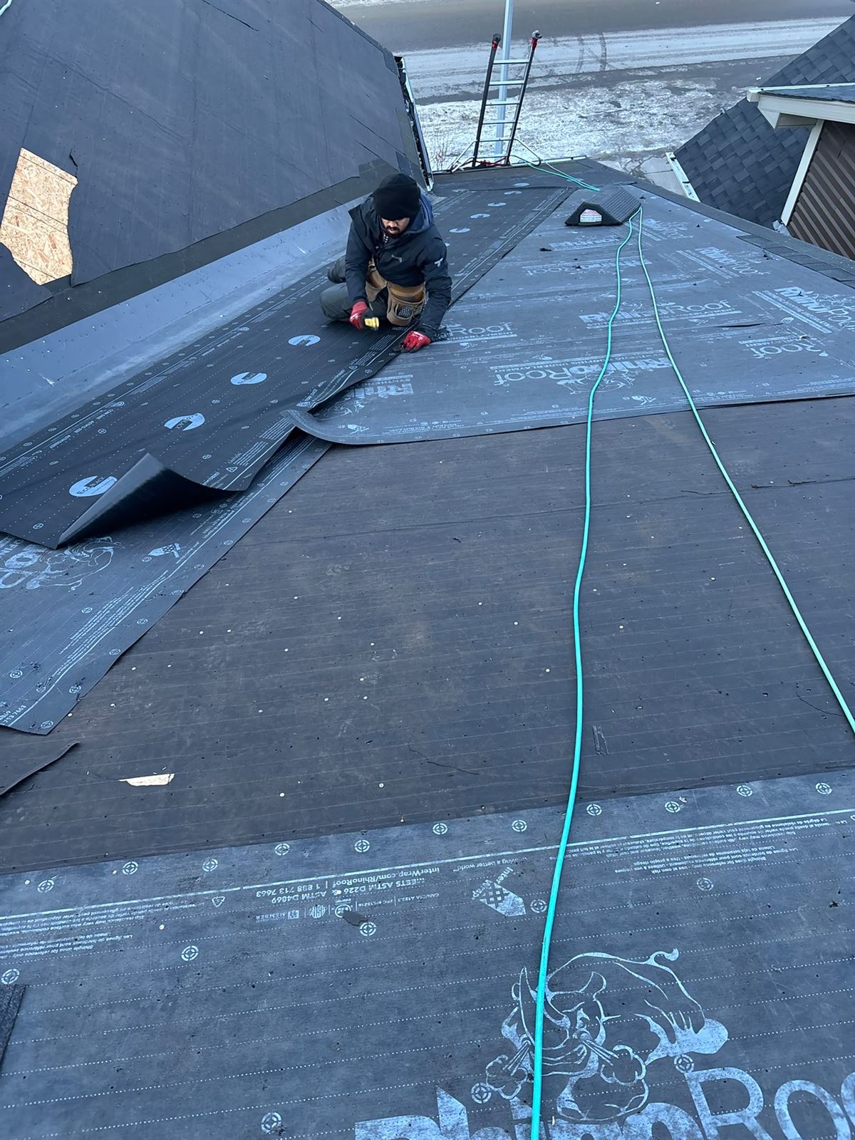 Silverstone roofer fastening synthetic underlayment on a Calgary roof