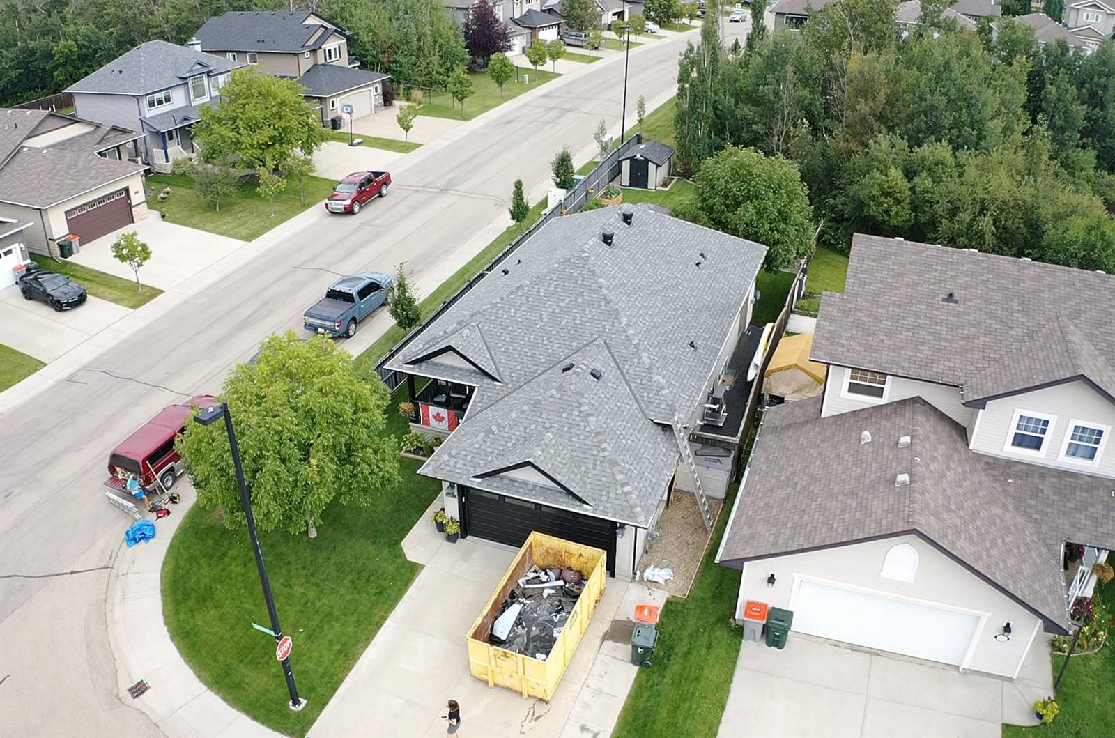 Aerial view of a Silverstone roofing job in progress with a disposal bin in the driveway