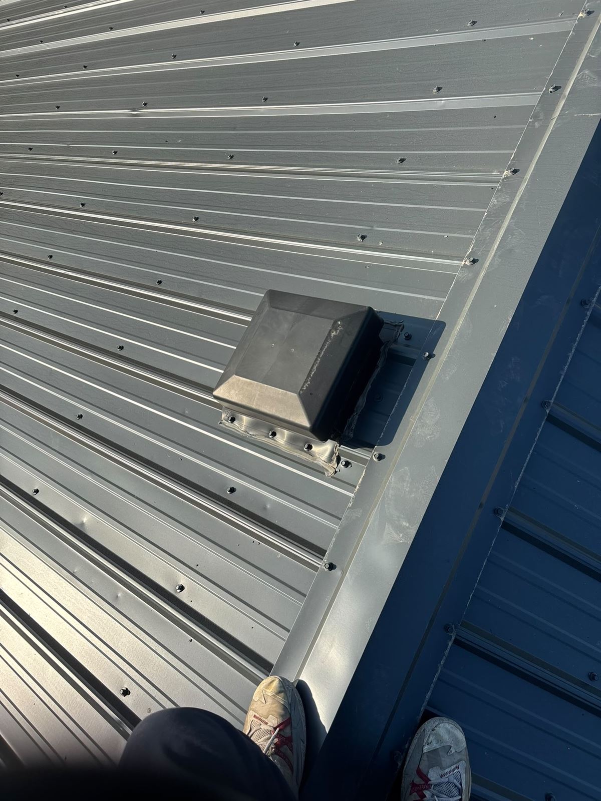 Grey metal roof panels and venting installed by Silverstone