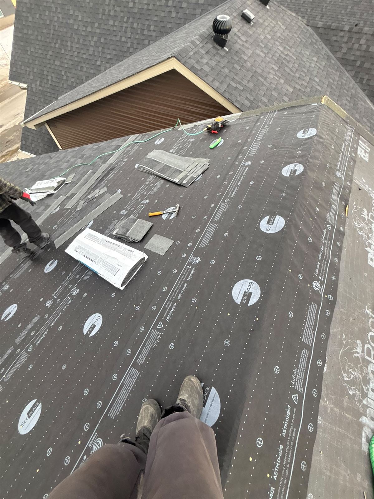 Roof deck prepared with underlayment and materials ready for shingles