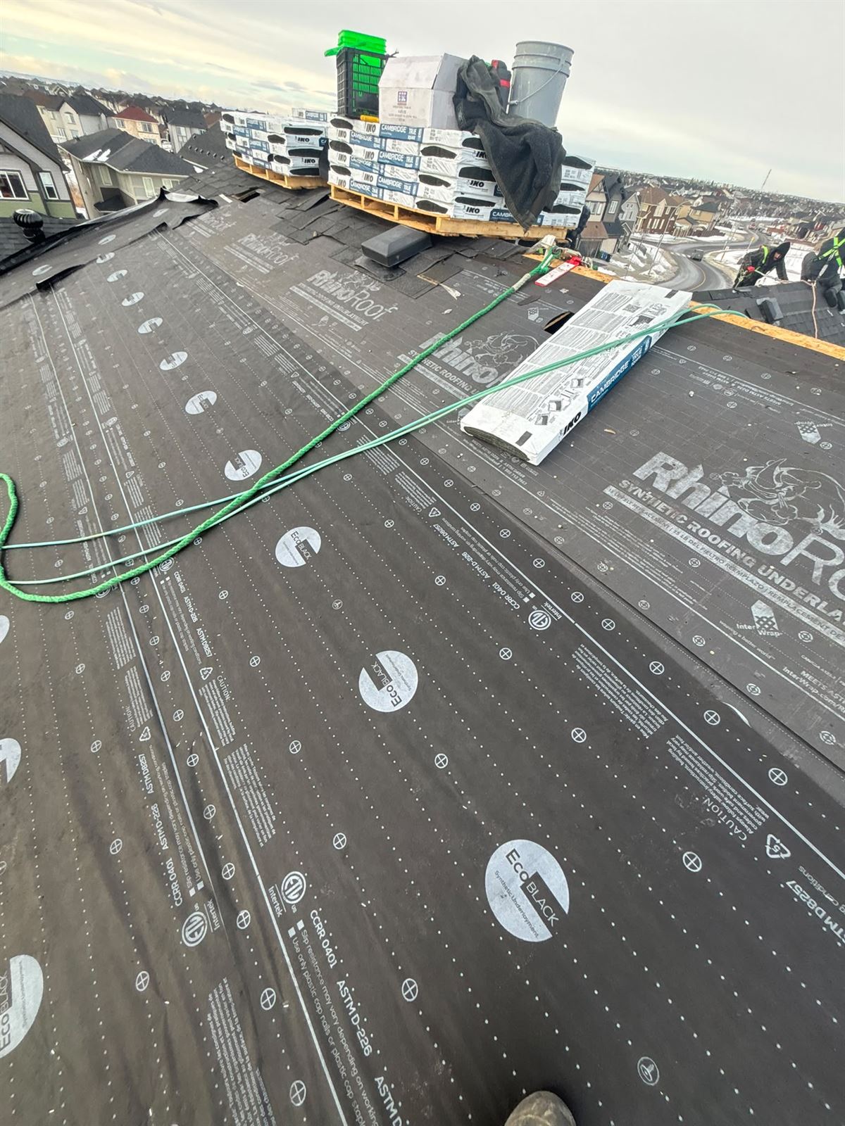Shingle bundles staged on underlayment during a Calgary roof replacement