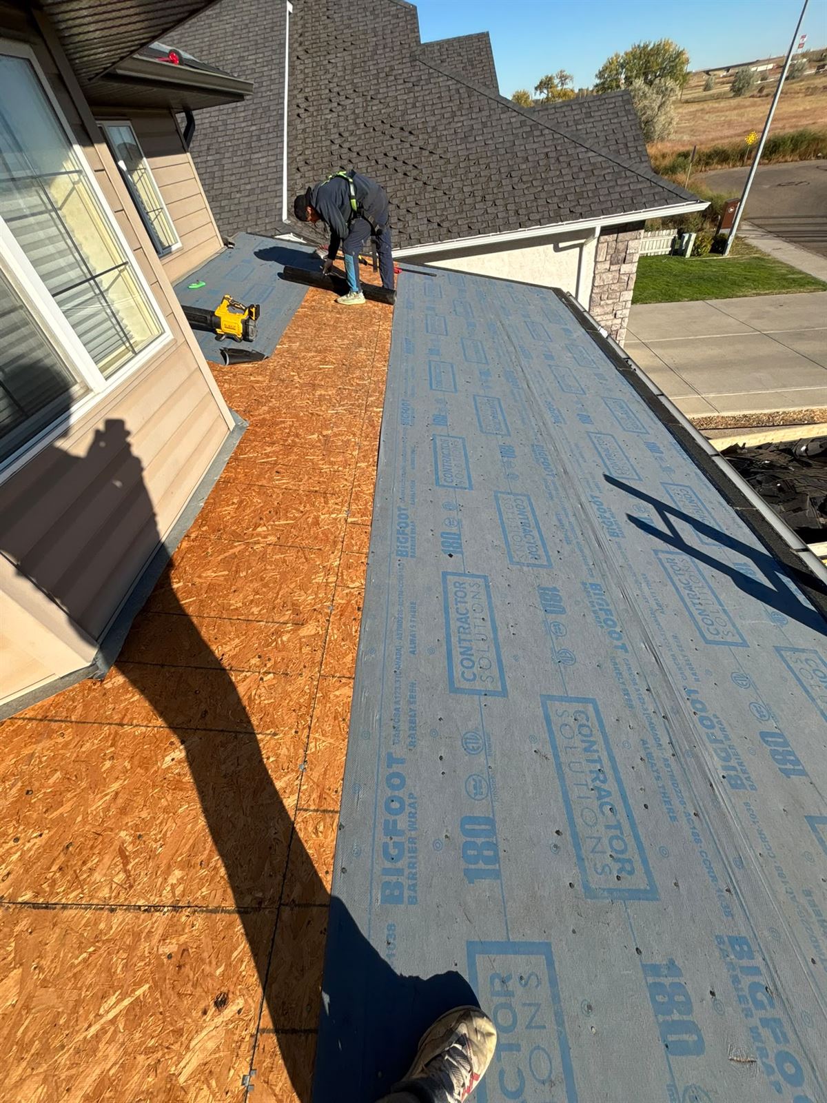 Crew laying underlayment across a re-decked Calgary bungalow roof