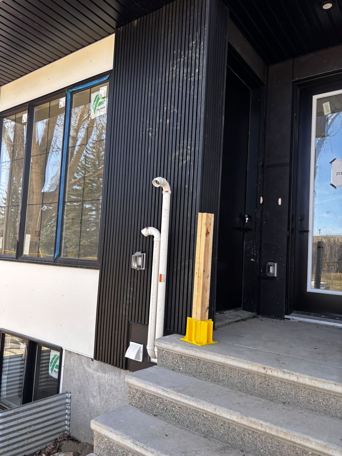 Black slat siding detail at a modern entrance with concrete steps