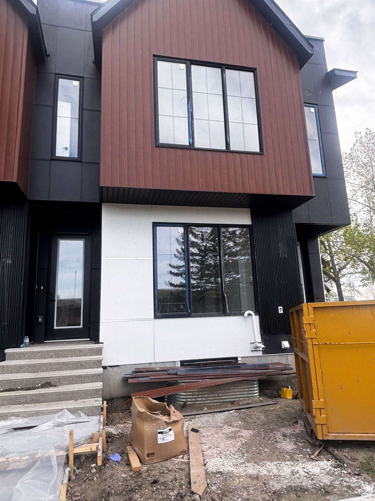 New townhome exterior in wood-tone and white with black trim